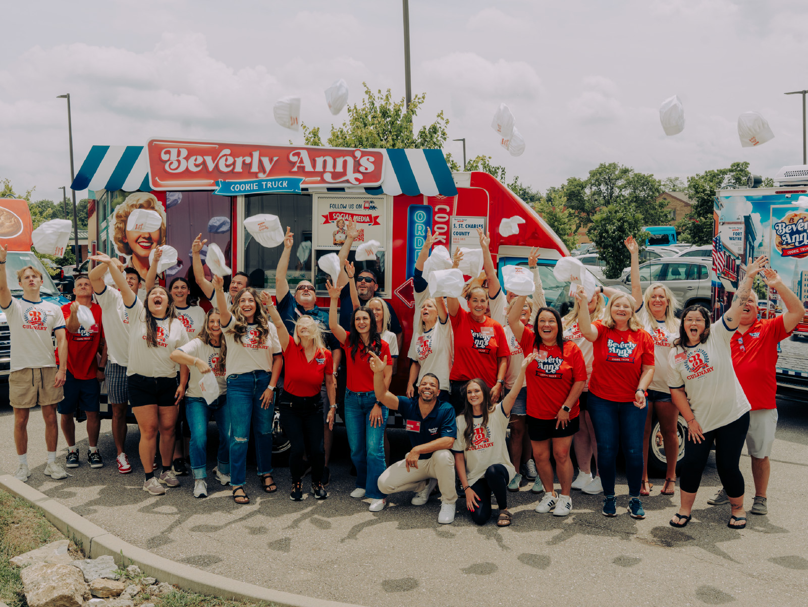 A large group of Travelin’ Tom’s employees and franchisees gather in front of a Tom’s Truck for a group photo